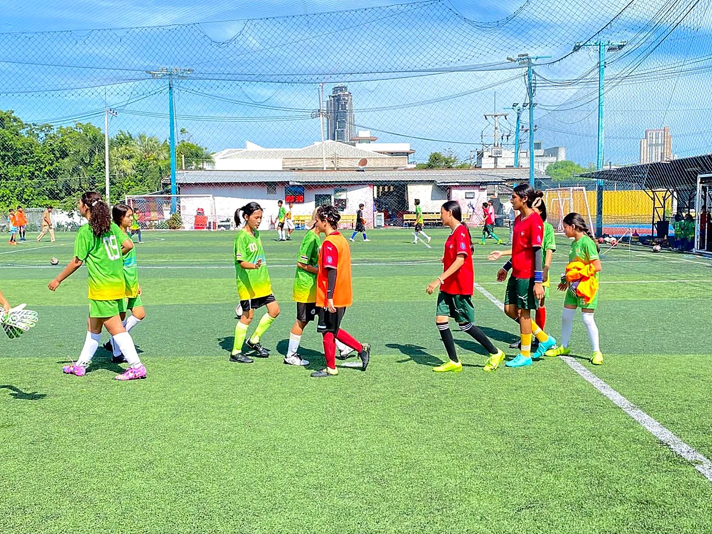 Hand to Hand football club players in green and red kits on the pitch during a match
