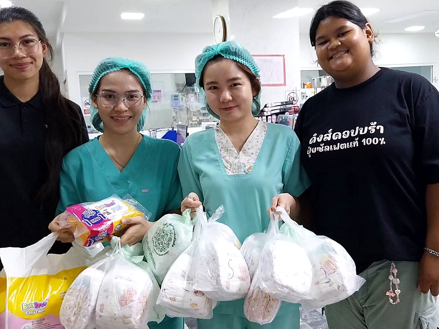Hand to Hand volunteers and hospital staff with donated diapers and baby supplies for families in the maternity ward