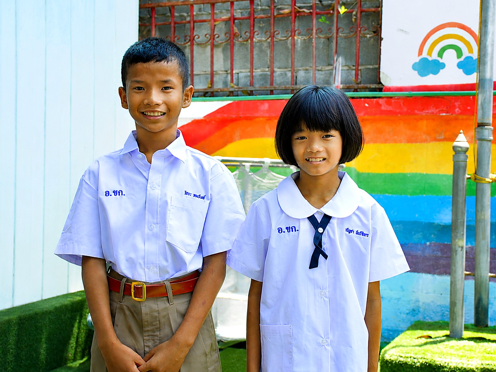 Two Hand to Hand scholarship students in school uniform smiling together